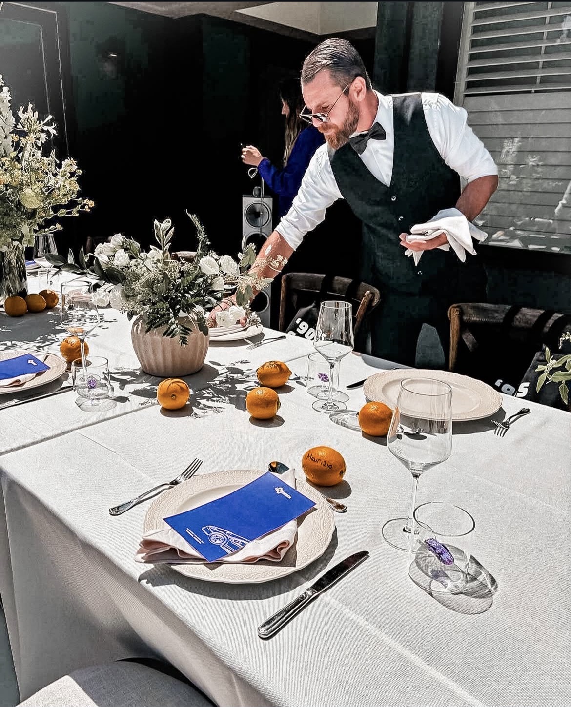 Professional server preparing elegant table setting at venue event